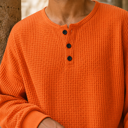 Nahaufnahme des Waffelstricks und der Knopfleiste am Henley-Pullover